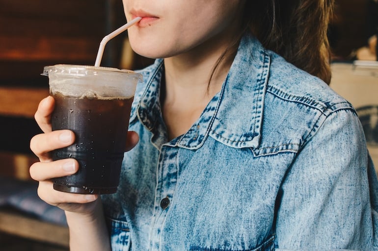 Coffee alternative. Woman sipping iced coffee