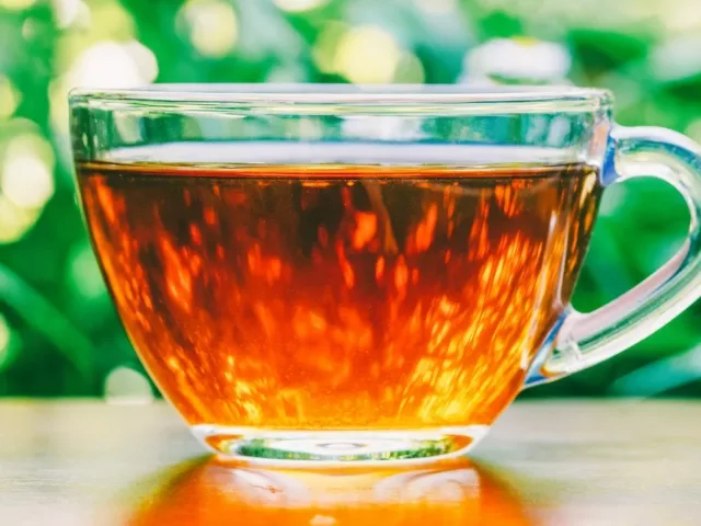 Clear class mug of black tea, which can aid weight loss